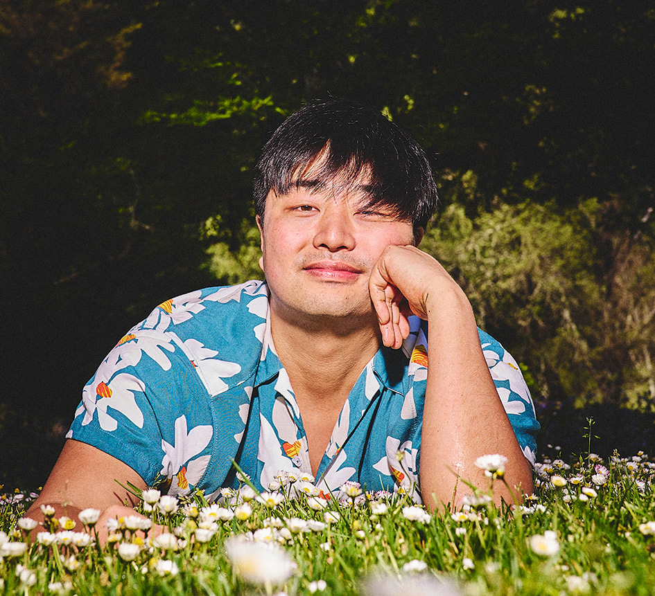 Offscript Vinito Winemaker Richard Yi sitting in a field of daisies.